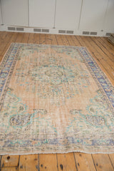 Distressed beige pile texture with short fringe and faded blue, mint tones.