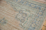 Distressed vintage Oushak carpet texture showing visible foundation and time-softened hues.