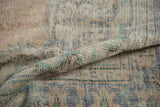 Distressed Oushak carpet pile close-up, showing foundation wear, dusty blush, and denim blue.