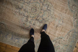 Distressed Turkish Oushak rug, showcasing faded beige, seafoam, and blue with visible foundation wear.