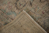 Distressed Oushak carpet, showing worn pile, visible foundation, and woven reverse.