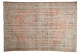 Distressed vintage Oushak carpet with faded blush pink, seafoam green vinery, and medallion pattern.
