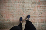 Distressed Oushak rug texture, showing worn blush pink, beige, and seafoam green pile.