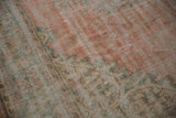 Distressed Turkish Oushak rug pile showing blush pink, seafoam green vinery, and wear.