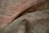 Close-up of the distressed vintage Oushak rug pile with knot heads, blush, seafoam, and beige.