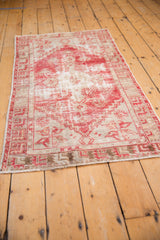 Secured end of vintage Oushak rug runner, with distressed texture and pale cherry red.