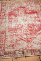 Distressed Oushak rug with worn texture, pale red and beige tones revealing foundation.