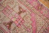 Distressed Oushak rug detail with fuchsia, coffee brown, and ivory geometric patterns.