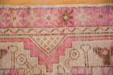 Distressed pile with fuchsia, beige, brown geometric stepped and starburst patterns.