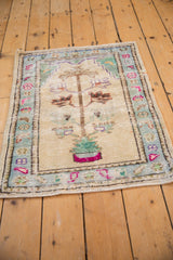 Distressed vintage Oushak rug with powder blue floral border and fuchsia tree-of-life pot.