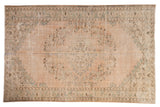 Distressed Oushak carpet, faded beige, quatrefoil medallion, muted green vinery.