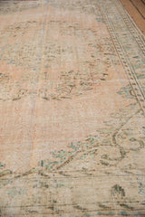 Distressed Oushak rug texture with mostly even wear, soft beige, and seafoam green tones.