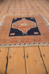 Vintage Oushak rug showing distressed copper border with blossoms and navy field.