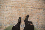 Distressed texture of vintage Oushak rug, showing diagonal striations, pale blue, and beige allover patterns.