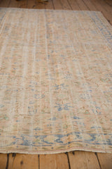 Distressed Oushak rug showing diagonal striations, mostly even wear, pale beige, blue, and green tones.