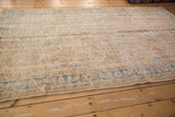 Distressed Oushak carpet border detail, pale sky blue vinery on worn beige pile.