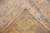 Distressed Oushak rug corner showing worn pile, subtle vinery, and hand-knotted foundation with diagonal striations.
