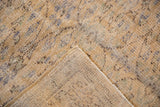 Distressed vintage Oushak rug, pale gold and blue worn pile, showing hand-knotted reverse.
