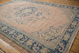 Distressed Oushak corner with dusty rose field, cobalt blue border, scrolling arabesques, even wear.