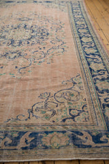 Distressed Oushak rug border in cobalt blue with scrolling arabesques on dusty rose.