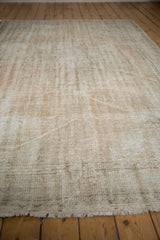 Distressed Oushak carpet showing worn pile, visible knot heads, and fringed edge.