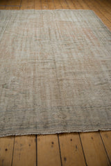 Distressed Oushak rug's worn edge with short, light-toned fringe and muted texture.