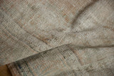 Distressed Oushak rug pile showing pale dusty rose, denim blue, and seafoam green flecks.