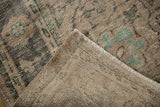 Distressed Oushak rug with soft ivory, charcoal, aqua green pile and visible hand-knotted foundation.