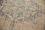 Distressed Oushak rug's faded pattern, foundation showing through, with charcoal and aqua mint.
