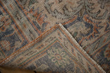 Folded vintage Oushak rug corner. Distressed pile, exposed foundation, intact selvage. Burnt orange, dusty blue, ivory.