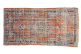 Vintage Oushak rug with worn madder red, cobalt blue, and ivory floral medallion.