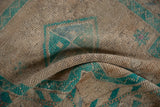 Distressed vintage Oushak rug showing worn beige pile and bright turquoise details.