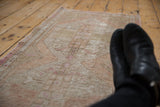 Distressed vintage Oushak runner with faded ivory, beige, and soft pink floral motifs.