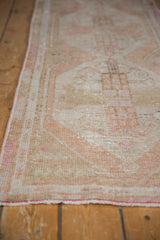 Intact pink side selvage and distressed beige pile of the vintage Oushak runner.