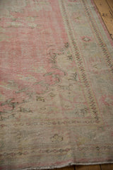 Distressed Oushak carpet border detail, showing worn pile with faded pink, ivory patterns.