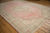 Soft, worn fringe and muted pink border of a vintage distressed Oushak rug.