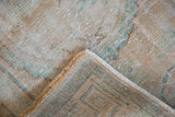 Distressed vintage Oushak rug pile in pale beige, apricot, seafoam, with woven backing and fringe.
