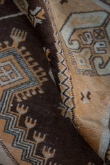 Distressed vintage Oushak runner pile, chocolate brown with pale apricot geometric motifs.