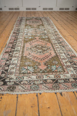 Distressed Oushak rug runner's secured fringe and faded geometric patterns.