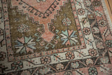 Distressed vintage Oushak runner with geometric patterns in dusty rose, olive, and blue.
