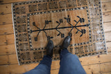Vintage distressed Oushak rug: deep navy tree-of-life motif, geometric border, abrashed beige.