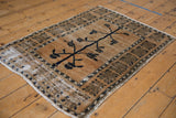 Distressed vintage Oushak rug corner showing worn beige pile, exposed foundation, and selvage.