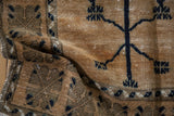 Worn pile texture and abrashed beige field with navy tree motif, Oushak rug.
