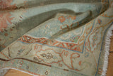 Distressed Oushak rug texture with muted powder blue, ivory, and cherry red motifs.