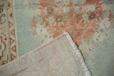 Worn powder blue and faded rose Oushak rug pile alongside its woven foundation.