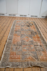 Corner detail of distressed Oushak rug runner, showcasing worn pile texture and geometric motifs.