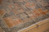 Burnt orange and charcoal brown geometric patterns on distressed Oushak rug runner.