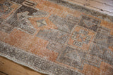 Vintage Distressed Turkish Oushak runner showing primitive geometric patterns, burnt orange, charcoal, and silver tones.