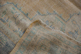 Softened saffron, ivory, and blue tones with wear to knot heads on vintage Oushak.