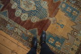 Distressed Oushak rug runner showing worn pile, faded sky blue, and copper tones.